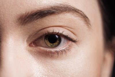 close up view of young woman green eye looking at camera